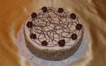 042 – Baileystorte, 20 cm Ø (10 – 12 kleine Stücke), dunkles Biskuit gefüllt mit Schokolade- und Kaffee-Baileyes-Creme. Mit Nüssen und Kirschen verziert.